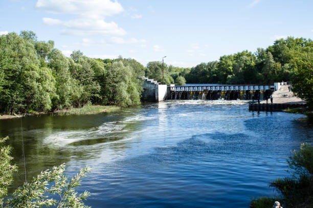 istock City landscape.  A wide dam through which a river flows, spray and white foam. 1188452480