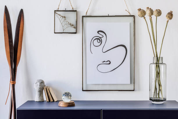 istock Modern scandinavian interior design with mock up photo frames, navy blue commode, flowers in vase and elegant accessories. Stylish home decor. Living room. Template Ready to use. 1188452897