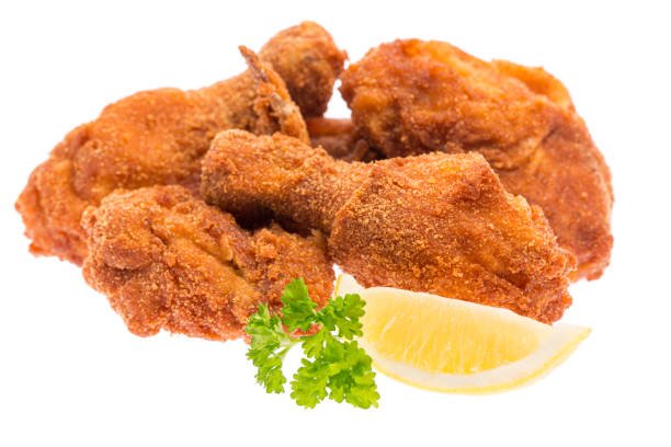 istock fried chicken pieces with lemon and parsley isolated on white background 1188455606