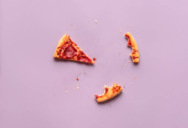 One pizza slice and leftovers. Salami pizza piece, crust scraps stock photo