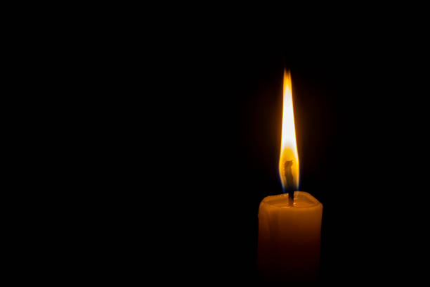 istock a lonely burning candle in the darkness 1188456979