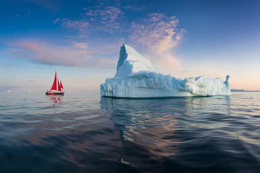 Disko Bay during midnight sun Ilulissat, Greenland. Studying of a phenomenon of global warming Ices and icebergs. Beautiful background landcape concept