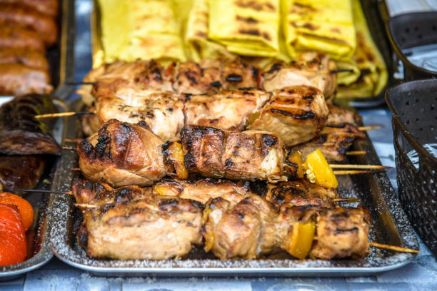 istock Grilled corn with assorted meat skewers or kebabs fresh from cooking over a barbecue fire on display at a market, buffet or catered event 1188457369