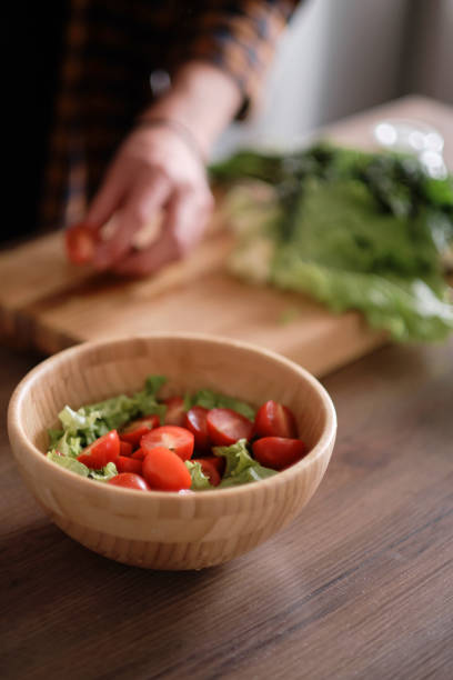 istock Man cutting green lettuce for salad 1188458772