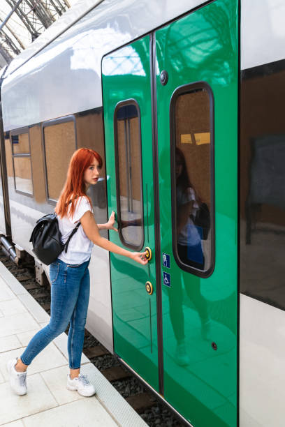istock Girl presses button on door to get into train 1188458904