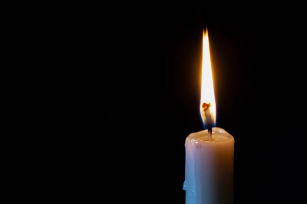istock a lonely burning candle in the darkness 1188461985