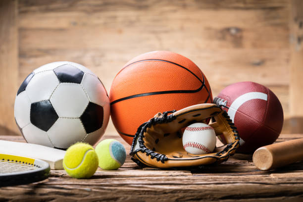 Variety Of Sport Accessories On Wooden Surface High Angle View Of Various Sport Accessories On Textured Wooden Surface sports stock pictures, royalty-free photos & images
