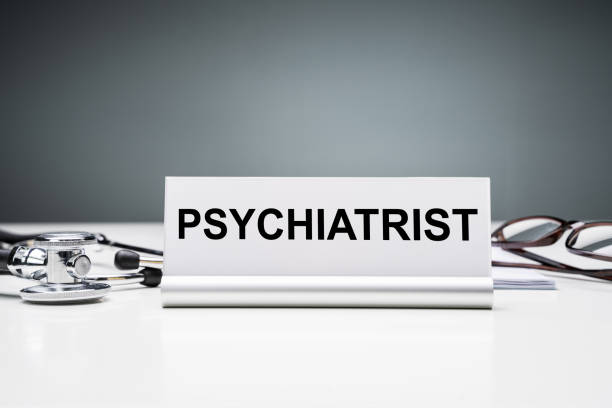 Stethoscope Near Nameplate With Psychiatrist Job Title Against Grey Background