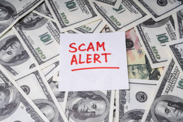 istock Background Of Dollar Bills With Scam Alert Text On Notepaper 1188462262