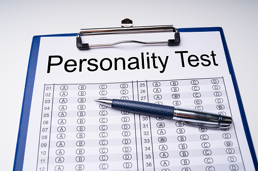 High Angle View Of Personality Test Sheet And Pen On Clipboard Over White Table