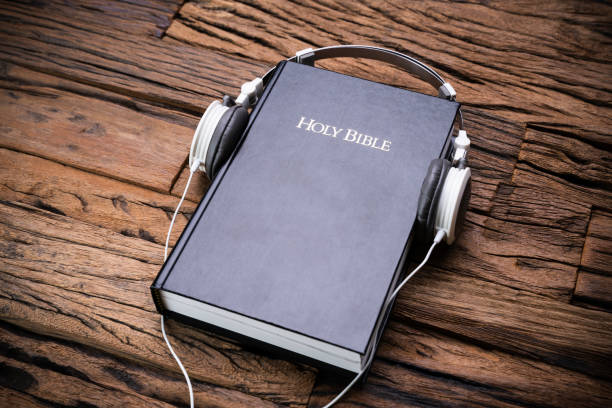 Headphones And Bible Over Wooden Surface