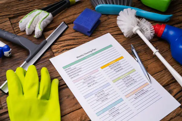 Photo of Cleaning Products Around Weekly Cleaning Plan Form With Pen