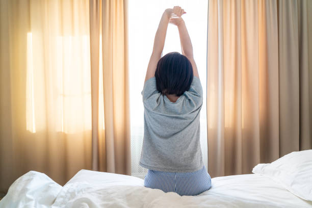istock Woman stretching in bed with arms high up 1188465107