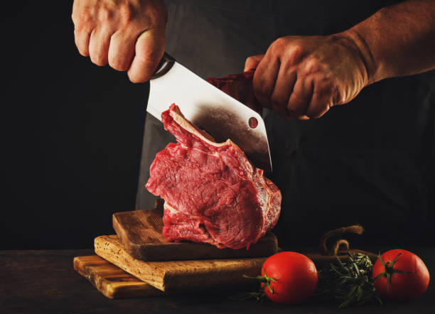 istock Male butcher cuts raw beef meat. 1188466761