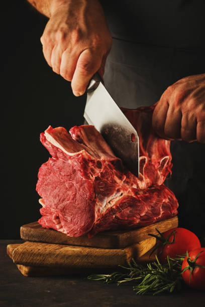 istock Male butcher cuts raw beef meat. 1188467458