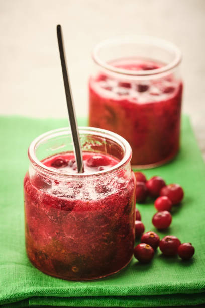 istock Cranberry jam in a glass bowl with fresh berries close-up. 1188467589