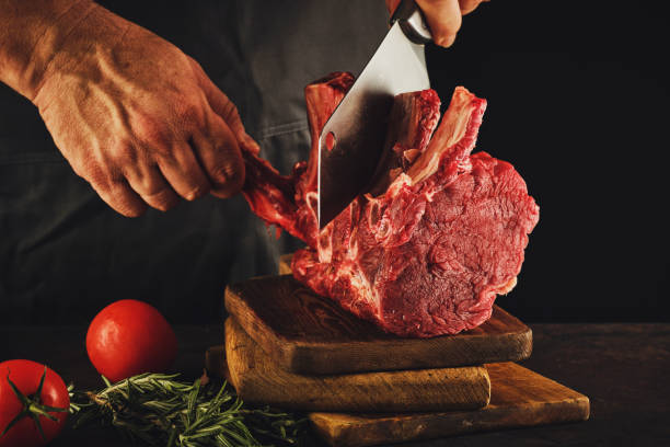 istock Male butcher cuts raw beef meat. 1188467715
