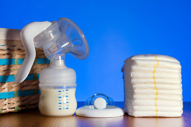 istock Breast pump stands among nipples and diapers 1188470020