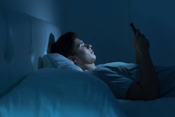 cansado y estresado en la cama por la noche - working bed smart phone bedroom fotografías e imágenes de stock