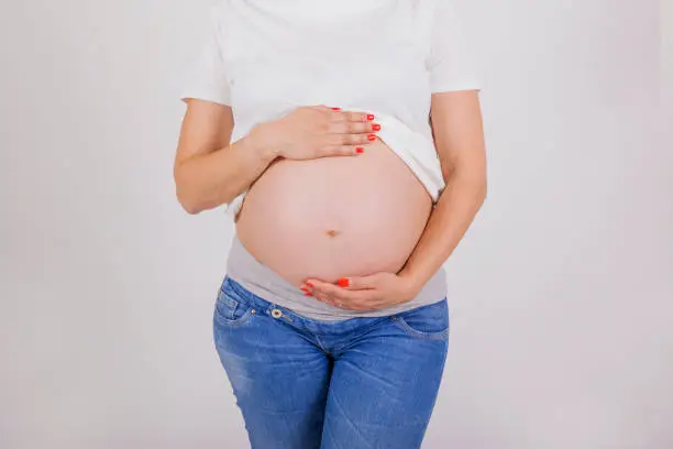 pregnant belly detail on white background