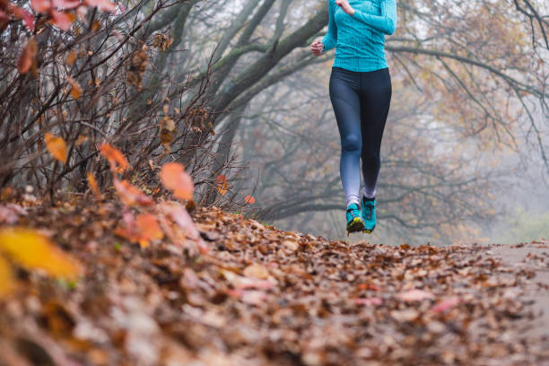 istock Woman jogging jumping in forest no face 1188475375