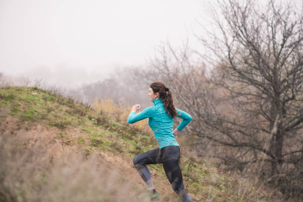 istock Sportive female climbing on hill in park 1188475422