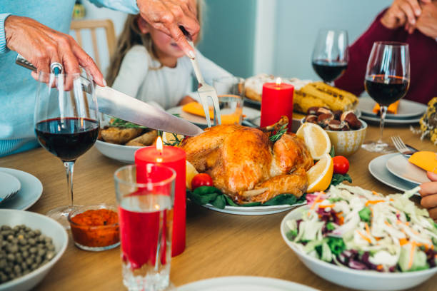 istock Unrecognizable person cutting roasted turkey during holiday dinner at dining table. 1188478778