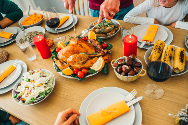 istock Unrecognizable person carving roasted turkey during holiday dinner at dining table. 1188478780