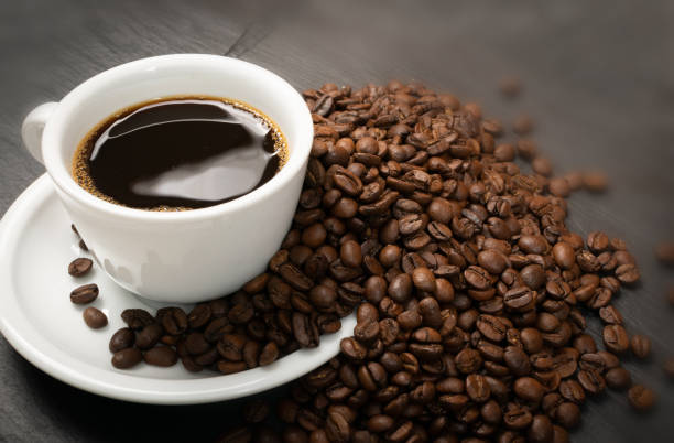 istock Hot coffee cup and coffee beans on black background top view 1188478933