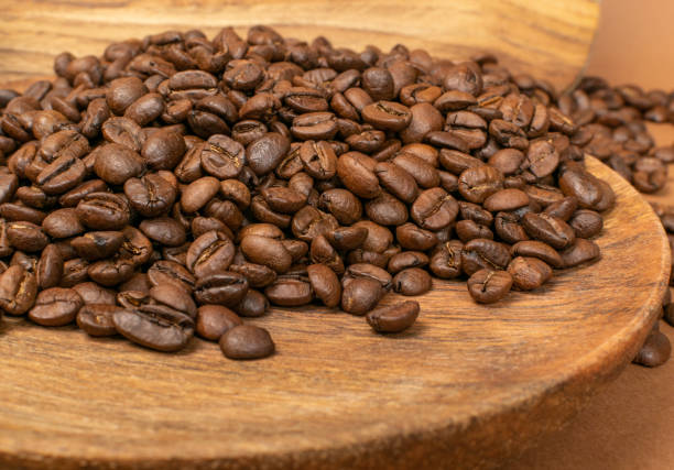 istock Dark brown whole coffee beans on wood background with copyspace 1188478964