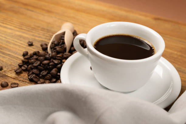 istock Hot coffee cup and coffee beans on wooden background 1188478977