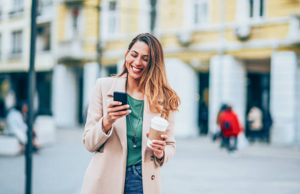 istock Beautiful elegant woman texting outdoors 1188480131
