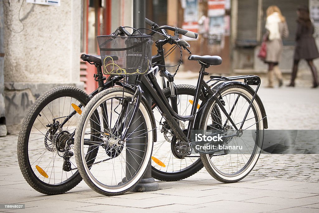 Bicycles Two different style bicycles anchored on an electrical pillar. Bicycle Stock Photo