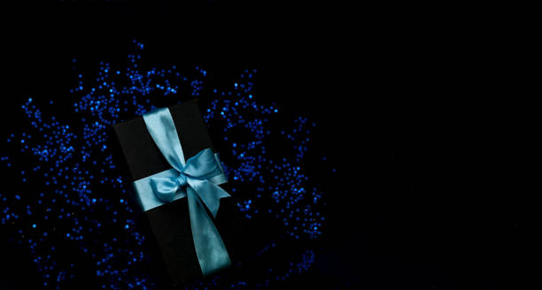 istock Gift box on black background with blue sparkles. New Year holidays concept 1188483511