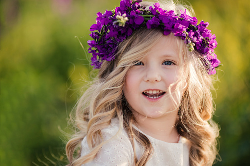 Smiling young girl with purple flowers in her hair