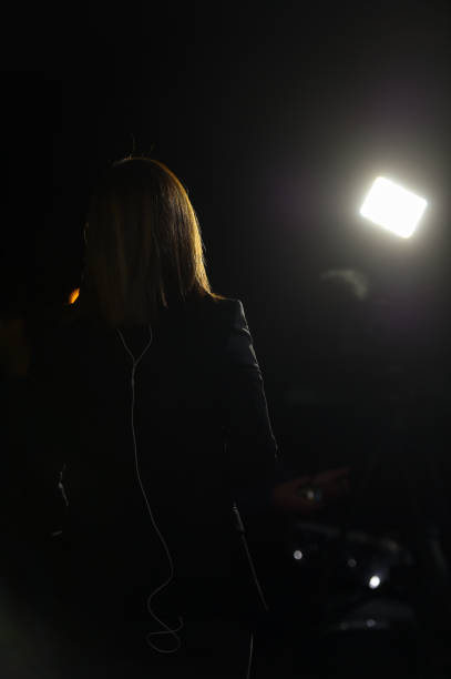istock Journalist making a live broadcast in front of a spotlight 1188486465