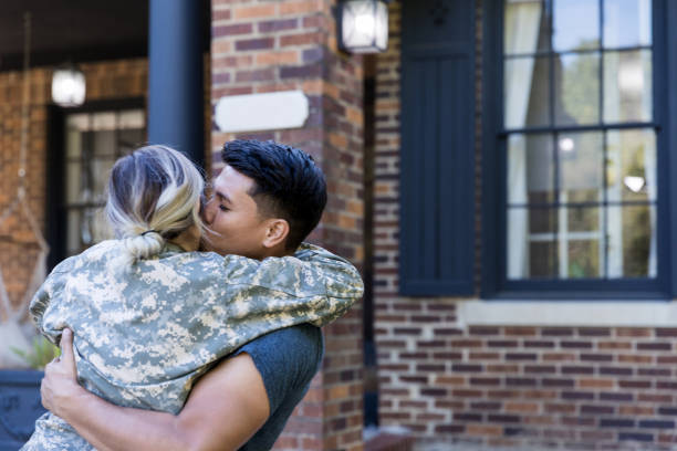 istock Husband kisses wife upon her return home from military assignment 1188487413