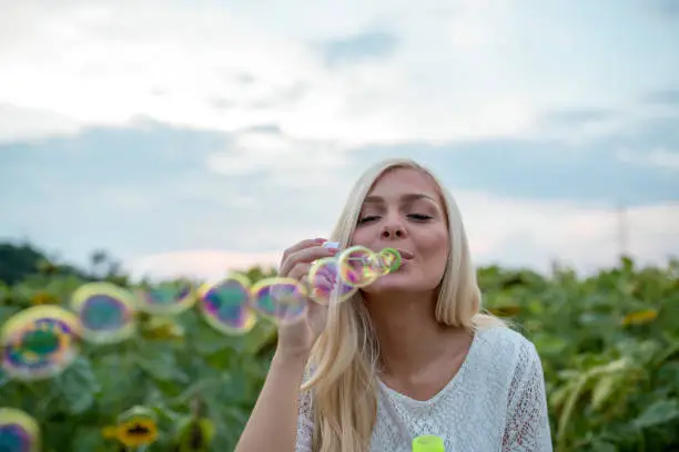 Photo of Pretty girl blowing bubbles soap in nature.