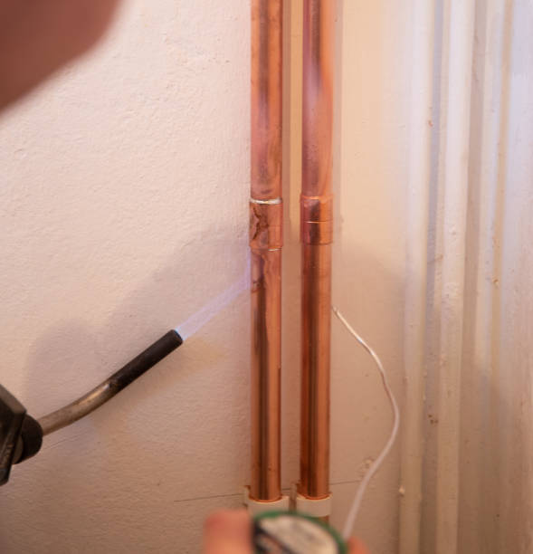 istock Plumber fixing jointing copper pipework with torch and solder in a residential home. 1188497169