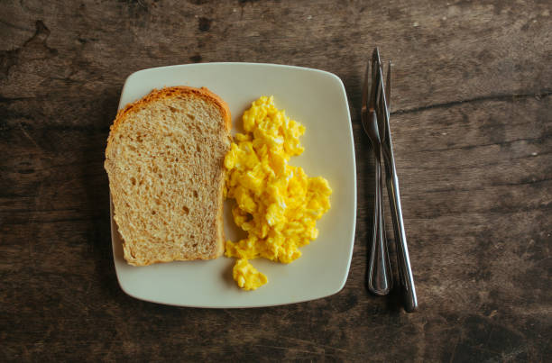 омлет с белым хлебом на белой тарелке - fork plate isolated scrambled eggs стоковые фото и изображения