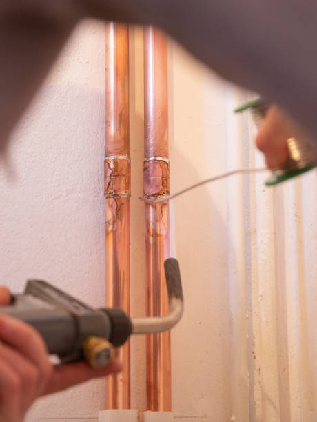 istock Plumber fixing jointing copper pipework with torch and solder in a residential home. 1188497290