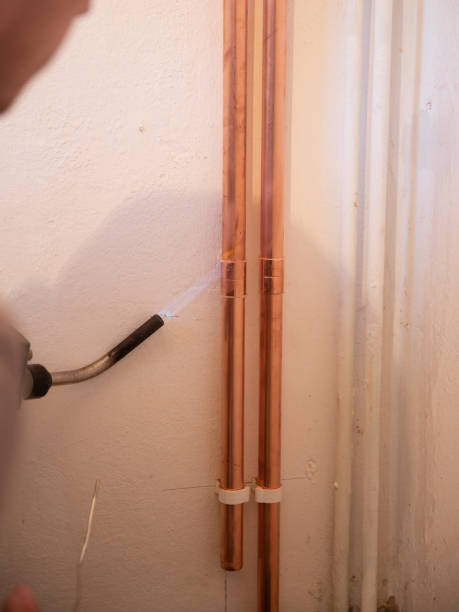istock Plumber fixing jointing copper pipework with torch and solder in a residential home. 1188497842