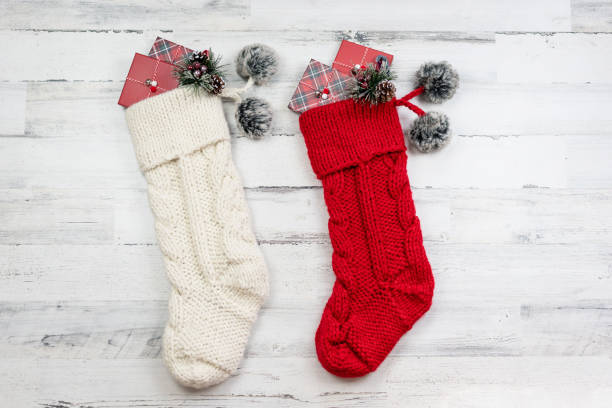 dos medias de navidad de punto sobre fondo de madera afligida - medias de liga fotografías e imágenes de stock