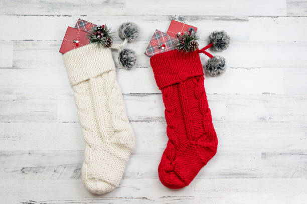 Two knitted Christmas stockings on distressed wood background stock photo