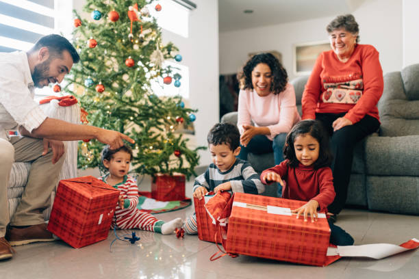 Family Christmas Morning Mexican family opening presents on Christmas morning unwrapping stock pictures, royalty-free photos & images