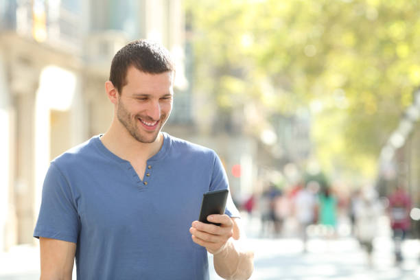 istock Happy man walking using mobile phone in the street 1188506973