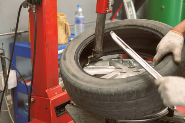 istock technician removing rubber from car wheel disc & balancing tyre on balancer in auto repair garage 1188510607