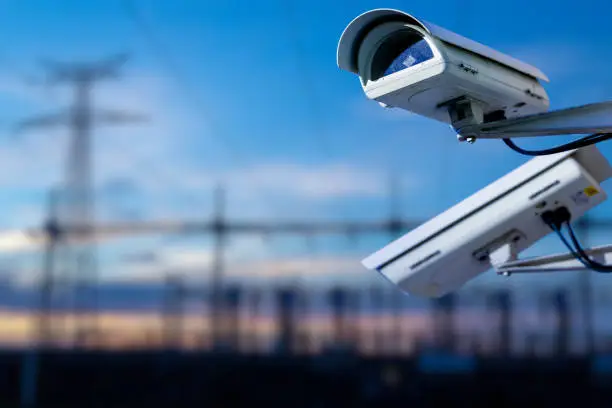 Photo of CCTV camera concept with power station on background