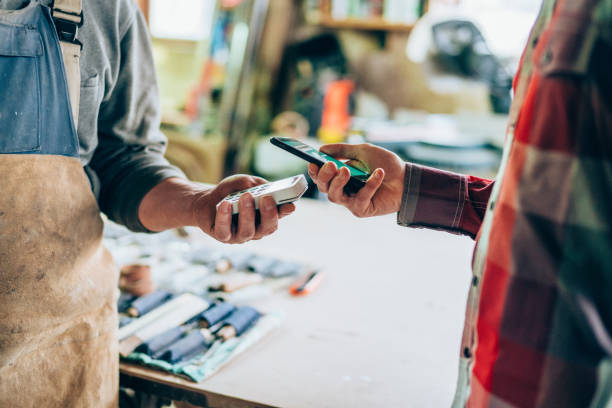 istock Man at wood workshop paying contactless with smartphone 1188512238