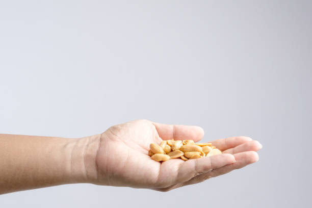istock Hand holding heap of salt roasted peanuts 1188516574